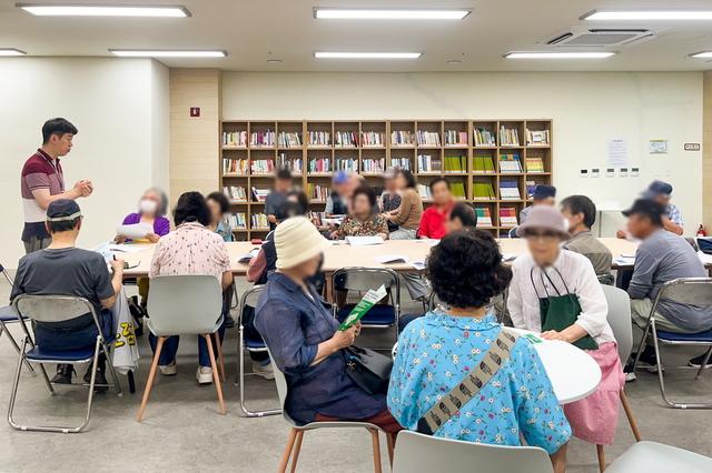 NSP통신-22일 수원시 관계자가 노인들에게 똑버스 이용법을 설명하는 모습. (사진 = 수원시)