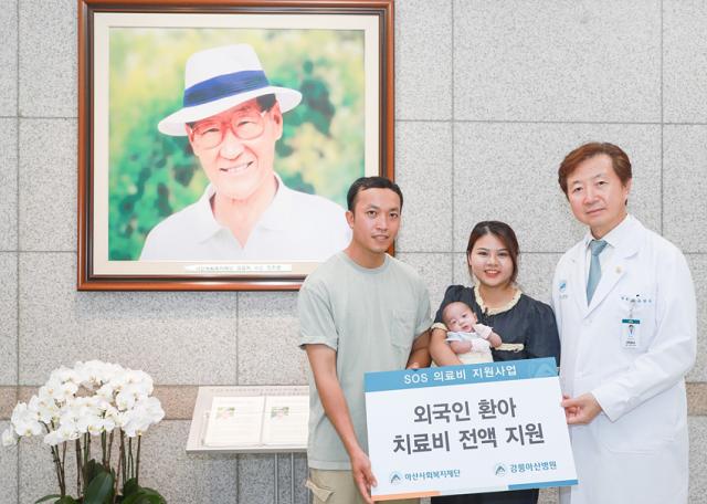 NSP통신-유창식 병원장과 환아의 가족이 고(故) 정주영 아산사회복지재단 설립자의 사진 앞에서 기념촬영을 하고 있는 모습. (사진 = 강릉아산병원)