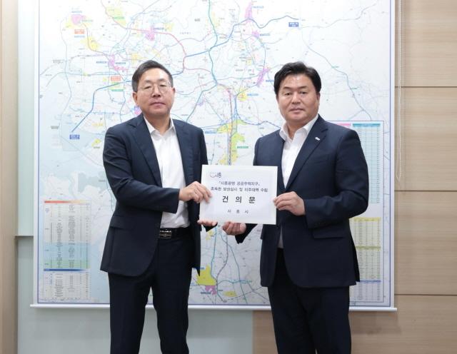 NSP통신-임병택 시흥시장(오른쪽)이 최용택 LH 광명시흥사업본부장에게 건의문을 전달하고 있다. (사진 = 시흥시)