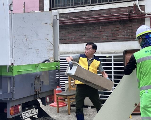 NSP통신-진교훈 서울 강서구청장(가운데)이 극한 폭우로 피해를 입은 방화동의 한 반지하 주택을 찾아 수해 복구 작업을 하고 있다.
