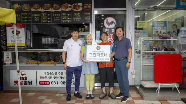 NSP통신-천계 옛날통닭 앞에서 김포FC 고정운 감독, 권일 선수단장, 박미성 대표 부부가 기념사진을 함께 촬영하고 있는 모습. (사진 = 김포FC)