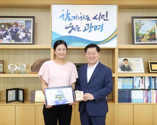 NSP통신-박승원 광명시장(오른쪽)이 21일 오전 시장실에서 1만 5000번째 1.5℃ 기후의병 가입자 최 모 씨(사진 왼쪽)를 만나 기념패를 전달하고 기념사진을 촬영하고 있다. (사진 = 광명시)