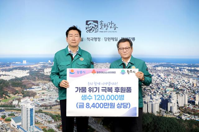 NSP통신-원강수 원주시장(왼쪽)이 가뭄으로 어려움을 겪고 있는 강릉시를 위해 생수 12만 병을 김홍규 강릉시장에게 전달하고 있는 모습. (사진 = 원주시)