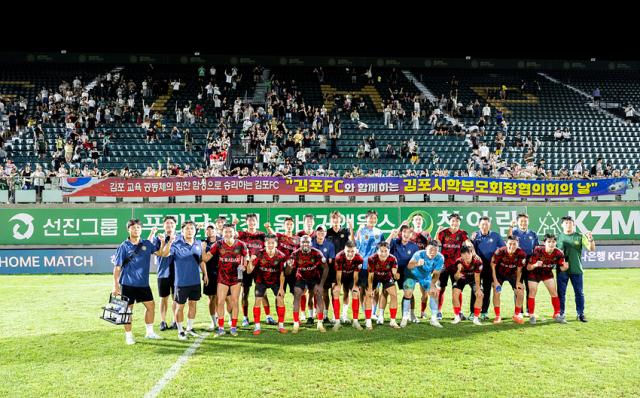 NSP통신-김포FC 선수단이 전남드래곤즈에 승리하고 팬들과 함께 위닝샷을 찍고 있는 모습. (사진 = 김포FC)
