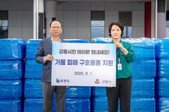 NSP통신-이기익 부천시 행정지원과장(왼쪽)이 강릉시 하정미 공보관에게 구호물품을 전달하고 있다. (사진 = 부천시)