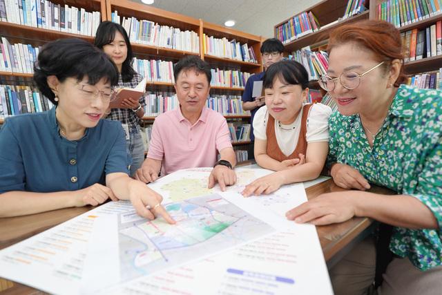 NSP통신-수원시 서둔동 주민들이 우리동네 자치계획을 들여다보며 회의를 하고 있다. (사진 = 수원시)