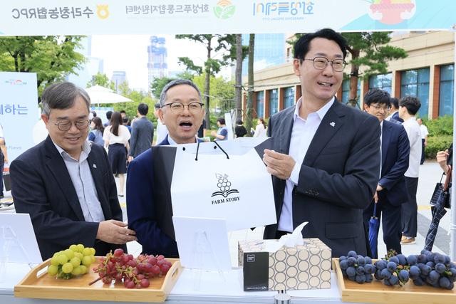 NSP통신-4일 정명근 화성시장(오른쪽 첫번째)이 국회 로컬푸드 직거래 장터에서 송산포도를 살펴보며 농업 관계자들과 대화를 하고 있다. (사진 = 화성시)