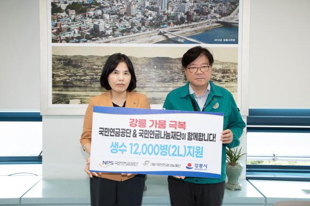 NSP통신-이여규 국민연금공단 복지이사(왼쪽)와 김동율 강릉시 행정국장(오른쪽)이 2리터 생수 1만 2000병 기부 전달식에서 기념 촬영 중이다. (사진 = 국민연금공단)