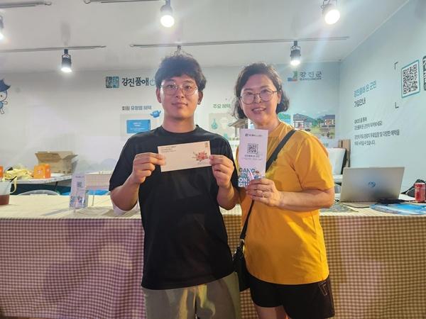 NSP통신-지난 달 열린 강진 하맥축제 현장 뽑기 이벤트 당첨자가 강진사랑상품권을 들고 기뻐하고 있다. (사진 = 강진군)