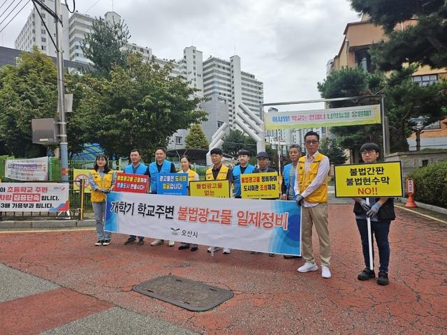 NSP통신-18일 학교 주변 불법현수막 일제 정비 참여자들이 캠페인을 펼치는 모습. (사진 = 오산시)