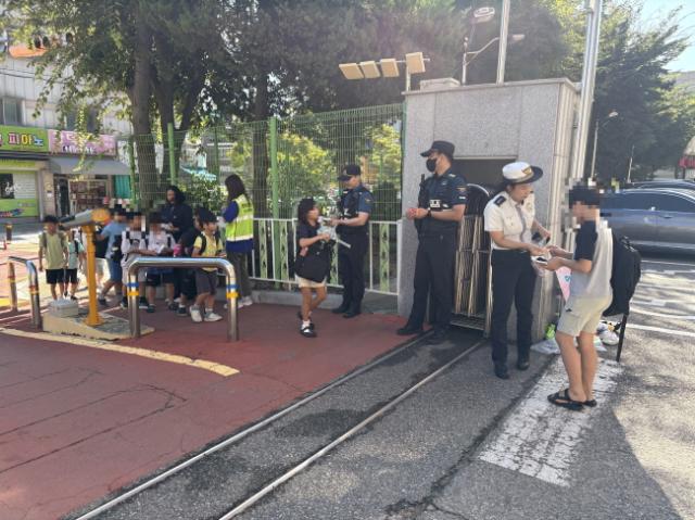 NSP통신-로보캅순찰대와 경찰이 18일 관내 초·중학교에서 등하굣길 안전캠페인을 진행하고 있다. (사진 = 안산시)