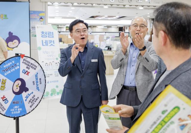 NSP통신-진교훈 강서구청장(정면 왼쪽)이 출근길 청렴 UP! 캠페인에서 청렴 룰렛지기로 변신해 직원들과 함께 문제를 풀며 소통하고 있다. (사진 = 서울 강서구청.)