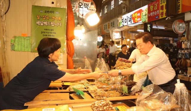 NSP통신-박승원 광명시장이 지난해 9월 추석 명절을 앞두고 새마을 전통시장을 찾아 광명사랑화폐로 상품을 구매하고 있는 모습. (사진 = 광명시)
