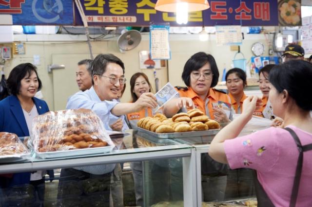 NSP통신-정왕시장을 찾은 김동연 지사가 소방관들과 함께 빵을 구매하고 있다. (사진 = 경기도)