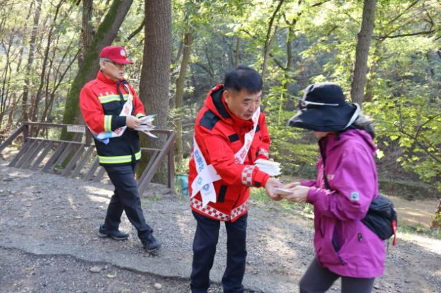 NSP통신-황인섭 동안구청장이 관악산 산림욕장에서 등산객에게 안전한 산행문화 홍보물을 건네고 있다. (사진 = 안양시)
