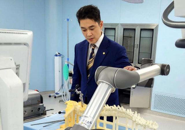 NSP통신-전석훈 경기도의원이 중국 난징의 첨단 피지컬 AI(Physical AI) 의료산업 현장을 방문해 의료용 로봇 시스템을 직접 살펴보고 있다. (사진 = 경기도의회)