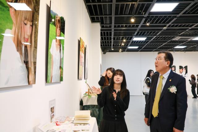 NSP통신-장광수 총장이 제1회 졸업전시회 나, 愛 행사에 출품된 작품들을 둘러보고 있다. (사진 = 안양대학교)