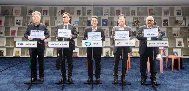 NSP통신-11일 오후 수원특례시 경기도서관에서 진행된 경기도-반도체 기업 재생에너지 파트너십 협약식에서 김동연 경기도지사, 송두근 삼성전자 부사장, 정상록 SK하이닉스 부사장, 안기현 한국반도체산업협회 전무, 사이피 우스마니(Saifi Usmani) 글로벌반도체협회 상무가 협약서 서명 후 기념촬영을 하고 있다. (사진 = 경기도)