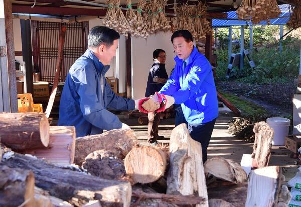 NSP통신-김한종 장성군수(사진 오른쪽)가 사랑의 땔감 나눔에 손을 보태고 있다. (사진 = 장성군)