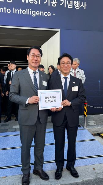 NSP통신-14일 기아 오토랜드 화성을 방문한 정명근 화성시장(왼쪽)이 김민석 국무총리에게 (가칭)화성항 신설 건의사항을 전달하고 기념촬영을 하고 있다. (사진 = 화성시)