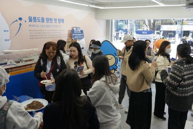 NSP통신-울릉도 나물 시식회 앞에서 시식을 하려는 관람객들로 북새통을 이루고 있다. (사진 = 울릉군)