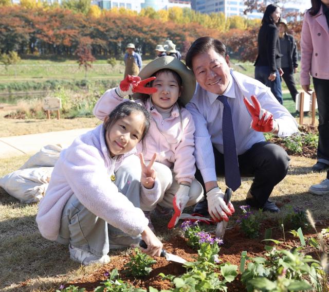 NSP통신-박승원 광명시장이 15일 안양천 지방정원 시범구간에서 개최한 정원 어울림 한마당에 참석해 아이들과 시민참여정원을 가꾸고 있다. (사진 = 광명시)