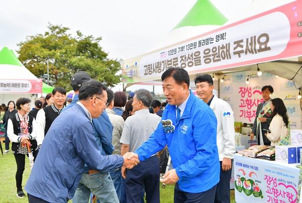 NSP통신-김한종 장성군수(사진 오른쪽)이 최근 열린 황룡강 가을꽃축제장에서 고향사랑기부제를 홍보하고 있다. (사진 = 장성군)