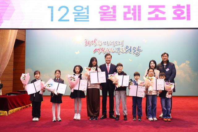 NSP통신-김성제 시장이 3일 시청 대회의실에서 열린 12월 월례조회에서 어린이 천 권 읽기 사업 수상 어린이와 가족들과 기념촬영을 하고 있다. (사진 = 의왕시)