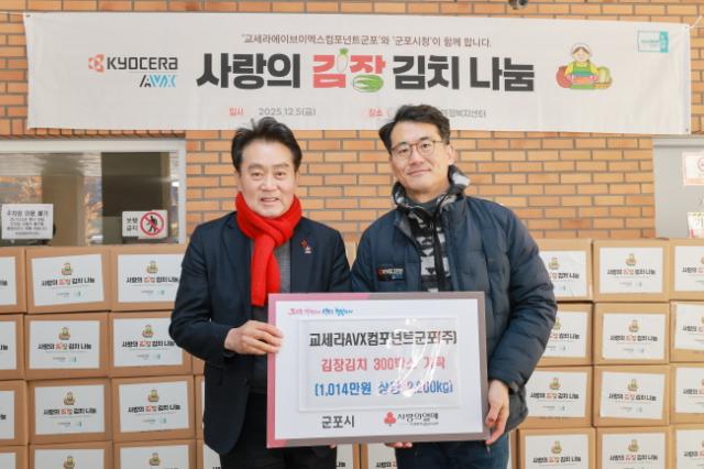 NSP통신-5일 교세라AVX컴포넌트군포가 김장김치 300박스를 군포시에 기탁했다. 사진 왼쪽부터 하은호 군포시장, 정성기 교세라AVX컴포넌트군포 대표. (사진 = 군포시)