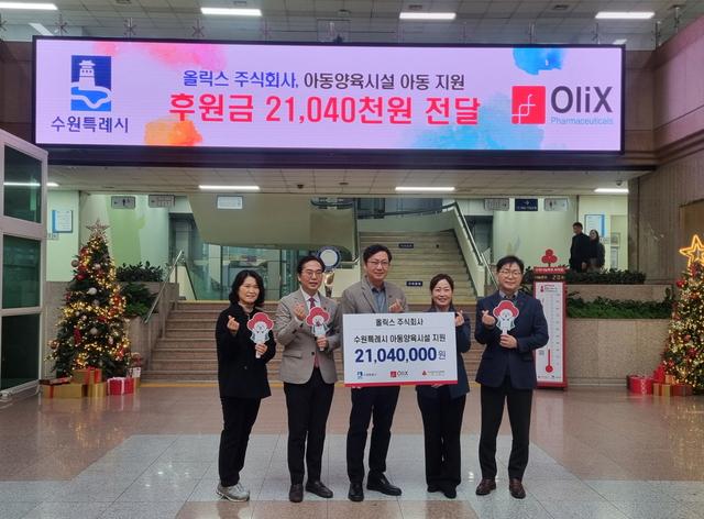 NSP통신-18일 올릭스, 수원시 관계자들이 성금 전달 후 기념촬영을 하는 모습. (사진 = 수원시)