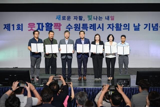 NSP통신-7월 수원시 첫 자활의날 기념식에서 이재준 수원시장(가운데)과 참석자들이 비전선언문을 들고 기념촬영을 하고 있다. (사진 = 수원시)