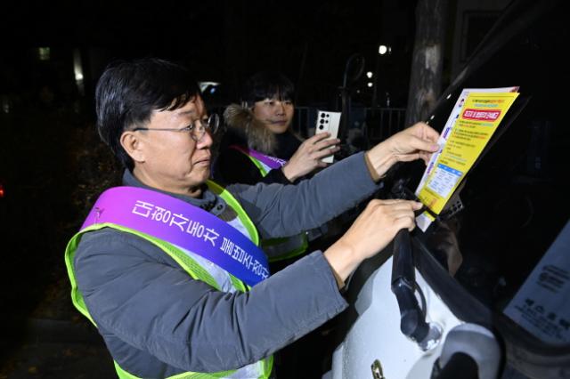 NSP통신-이민근 안산시장이 20일 새벽시간 단원구 와동 일대에 불법 밤샘주차된 대형차랑에 계도문을 부착하고 있다. (사진 = 안산시)