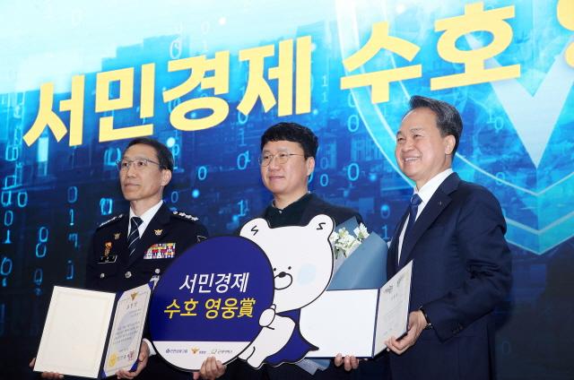 NSP통신-6일 서울 서대문구에 위치한 경찰청 어울림마당에서 경찰청(청장 직무대행 유재성)과 함께 제5회 서민경제 수호 영웅상 시상식을 개최했다. 행사에 참석한 진옥동 신한금융그룹 회장(오른쪽)과 유재성 경찰청장 직무대행이 서민경제 수호 영웅상 수상자와 기념촬영을 하고 있다. (사진 = 신한금융그룹)