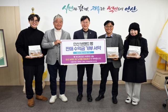 NSP통신-이민근 안산시장(가운데)이 27일 안산시 브랜드빵 노적봉 별빛츄리 판매 수익금 기부 서약식을 마치고 참여자들과 함께 기념촬영을 하고 있다. (사진 = 안산시)