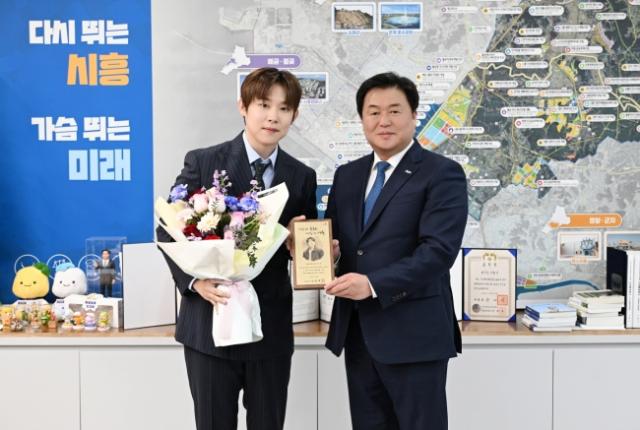 NSP통신-임병택 시장이 시흥시 명예문화홍보대사로 위촉된 가수 진욱(왼쪽)과 함께 기념촬영을 하고 있다. (사진 = 시흥시)