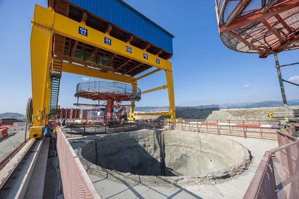 NSP통신-부산항 신항 북측 컨테이너부두 2단계 항만배후단지 조성 공사 현장의 갠트리 크레인 아래에 굴착이 완료된 수직터널 (사진 = DL이앤씨)