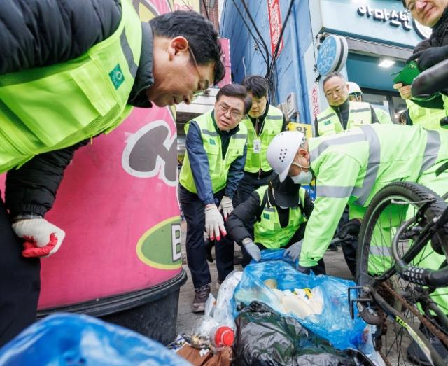 NSP통신-진교훈 강서구청장(왼쪽 두 번째)이 1월 5일 까치산역 일대 무단투기 상습 지역을 찾아 무단투기된 버려진 봉투를 뜯어 내용물을 확인하는 파봉단속을 하고 있다. (사진 = 서울 강서구청.)