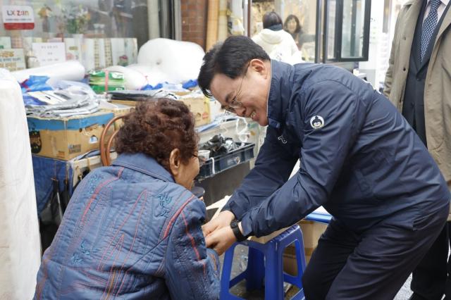 NSP통신-진교훈 서울 강서구청장(오른쪽)이 11일 설 명절을 앞두고 까치산시장을 찾아 장을 보러 나온 주민과 인사를 나누고 있다. (사진 = 서울 강서구청)