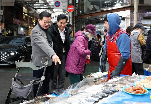 -11일 오산시의회 이상복 의장왼쪽과 성길용 부의장왼쪽 두번째이 전통시장에서 생선을 살펴보고 있는 모습 사진 오산시의회