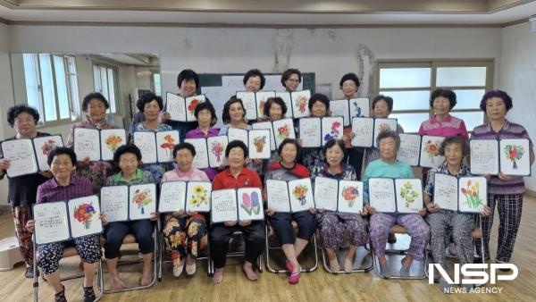 NSP통신-순천시 황전 비촌마을 주민들이 마을자원기록 프로그램의 일환으로 마을 달력에 삽입될 그림을 완성한 뒤 단체 기념사진을 촬영하고 있다 (사진 = 순천시)