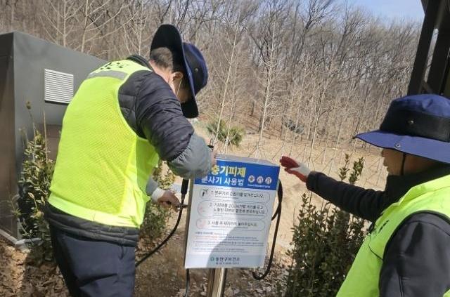 NSP통신-동안구보건소 관계자가 관양고등학교 인근에 설치된 해충기피제함을 점검하고 있다. (사진 = 안양시)