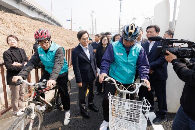 NSP통신-참석자들이 준공식 후 태양광 패널집광판 아래 자전거길을 직접 달리는 라이딩 퍼포먼스에 참여하고 있다 사진 경기도