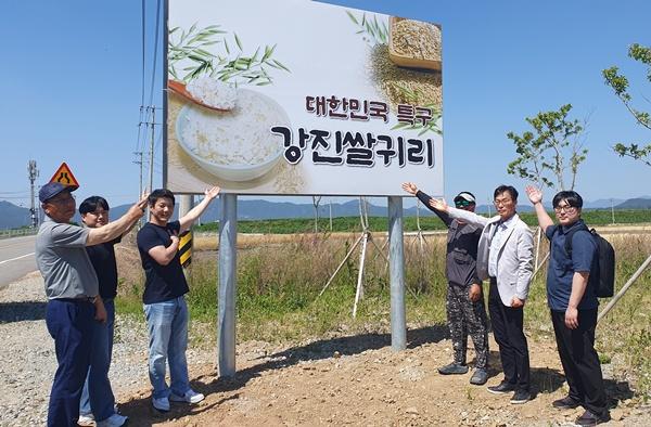 NSP통신-강진군 쌀귀리연구회 임원과 유통 관계자들이 쌀귀리 홍보 간판 앞에서 기념촬영을 하고 있다 사진 강진군