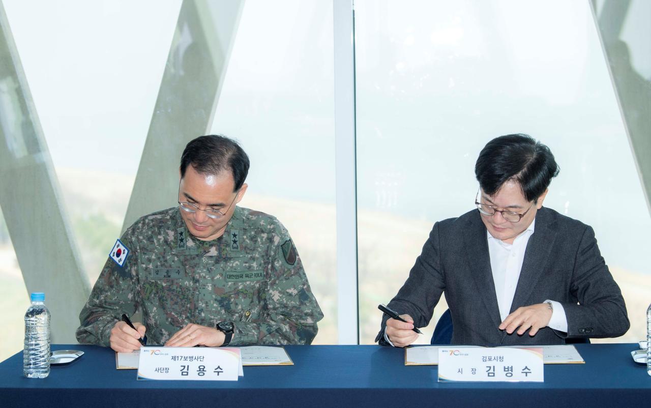 -김병수 김포시장오른쪽과 김용수 제17보병사단장이 수정 합의각서를 체결하고 있는 모습 사진 조이호 기자
