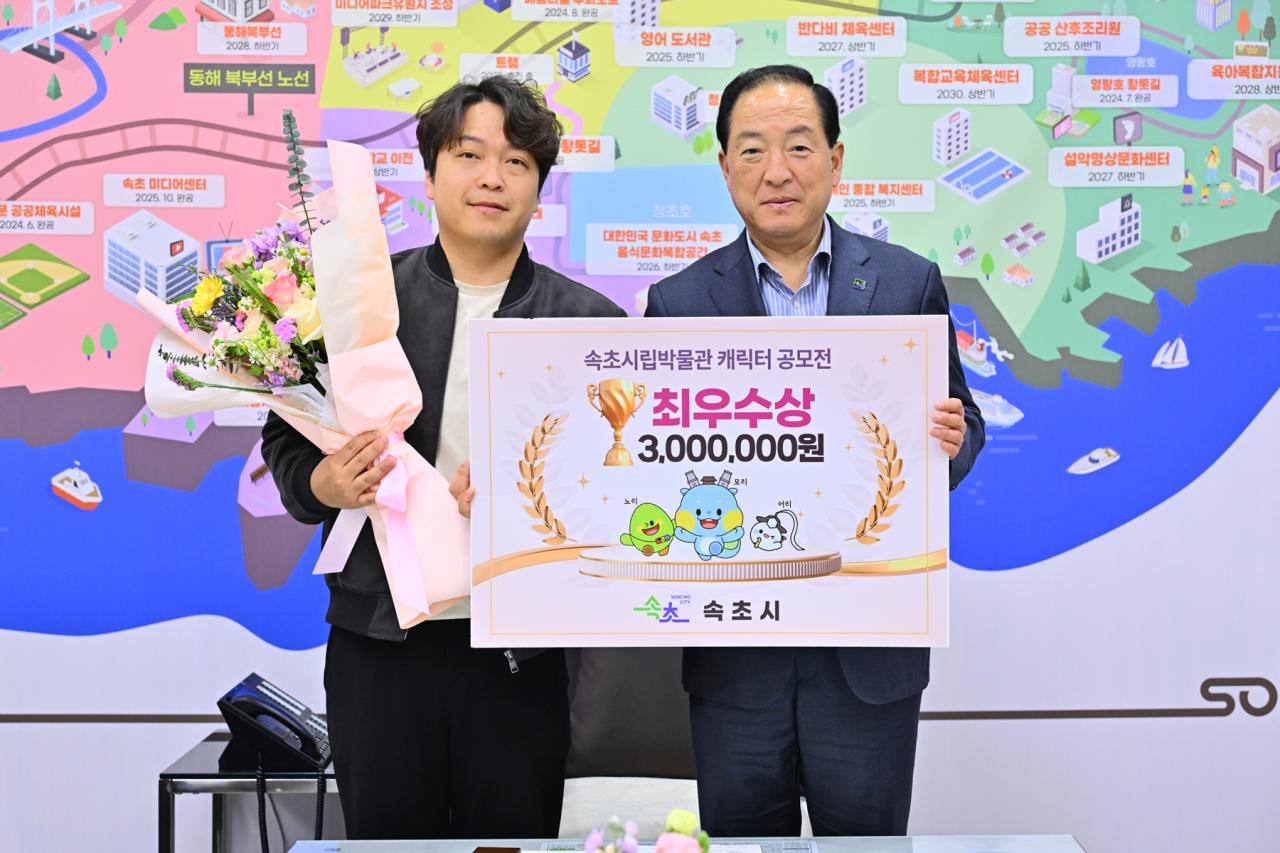 -이병선 속초시장이 캐릭터 공모전 최우수상 수상자에게 표창장을 전달하고 있는 모습 사진 속초시