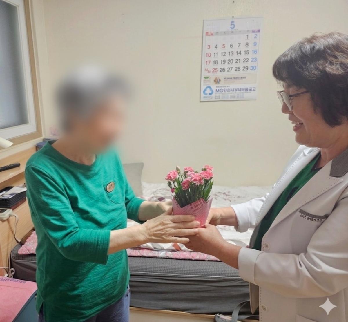 -6일 단원보건소 방문간호사가 관내 독거노인 가정을 방문해 카네이션을 전달하고 있다. (사진 = 안산시)