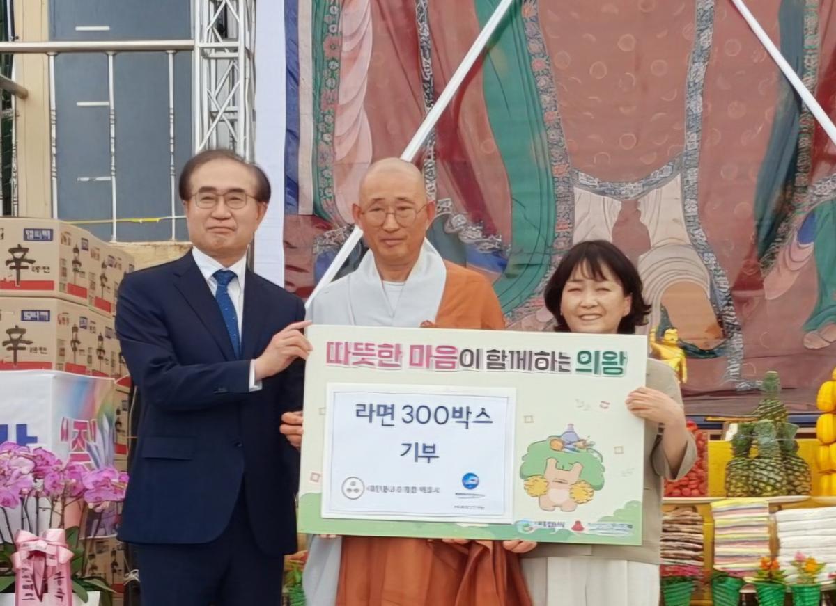 -법진 주지 스님과 전문순 복성산업개발 부회장이 라면 300박스를 기탁한 가운데 기념촬영을 하고 있다. (사진 = 의왕시)