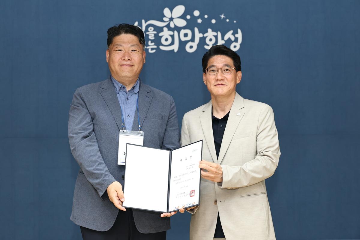 -29일 윤성진 화성시장 권한대행(오른쪽)이 제1기 화성특례시 건설공사 시민감리단원에게 위촉장을 수여하고 기념촬영을 하고 있다. (사진 = 화성시)