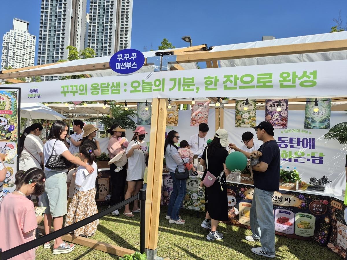 -통일부 청년인턴들이 기획한 참여형 미션 부스 ‘꾸꾸의 옹달샘’에서 시민들이 미션을 수행하기 위해 차례를 기다리며 행사를 즐기고 있다. (사진 = 화성시)