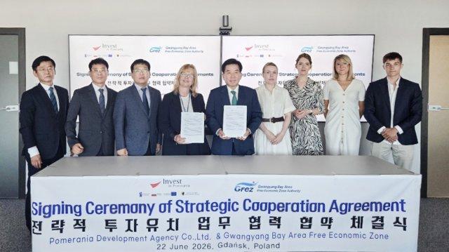 -구충곤 광양경자청장(가운데 오른쪽)과 카타르지나 마투샤크 드지에르진스카 포메라니아 개발공사 대표이사(가운데 왼쪽)가 협약서 들고 양 기관 관계자들 업무 협약식 기념 찰영 하고 있다